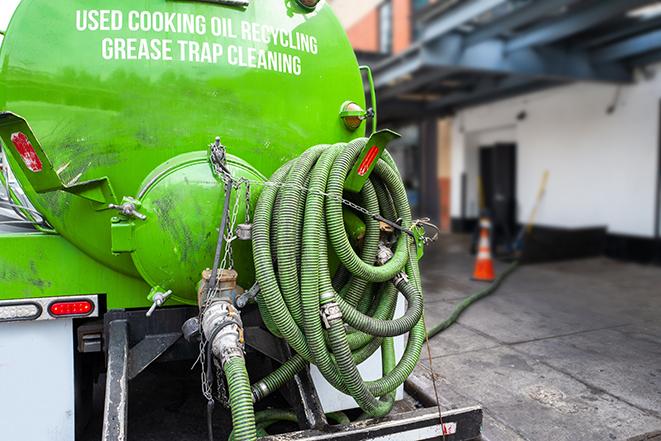 a grease trap being pumped by a sanitation technician in Waukesha